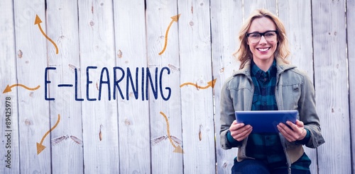 E-learning against smiling blonde in glasses using tablet pc