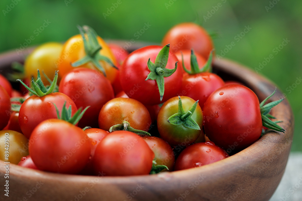 Ripe Cherry tomatoes in a wooden plate