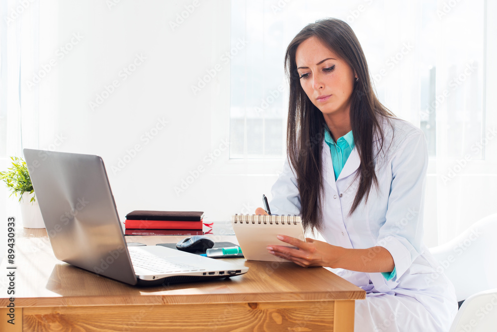 Portrait of physician working in her office writing prescription Portrait of physician working in her office writing prescription