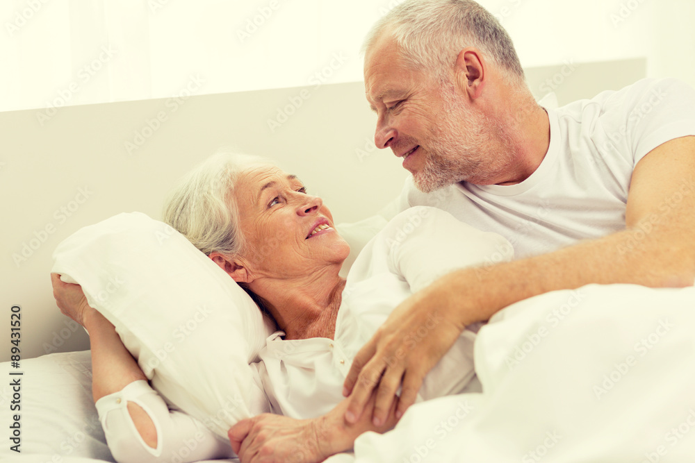 happy senior coupler lying in bad at home happy senior coupler lying in bad at home
