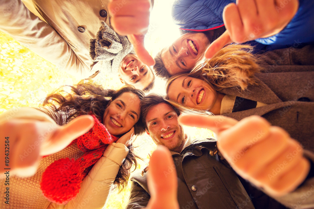 Obraz premium group of smiling men and women in autumn park
