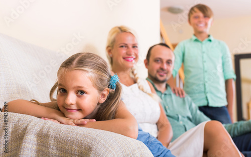 parents with two children posing in home interior