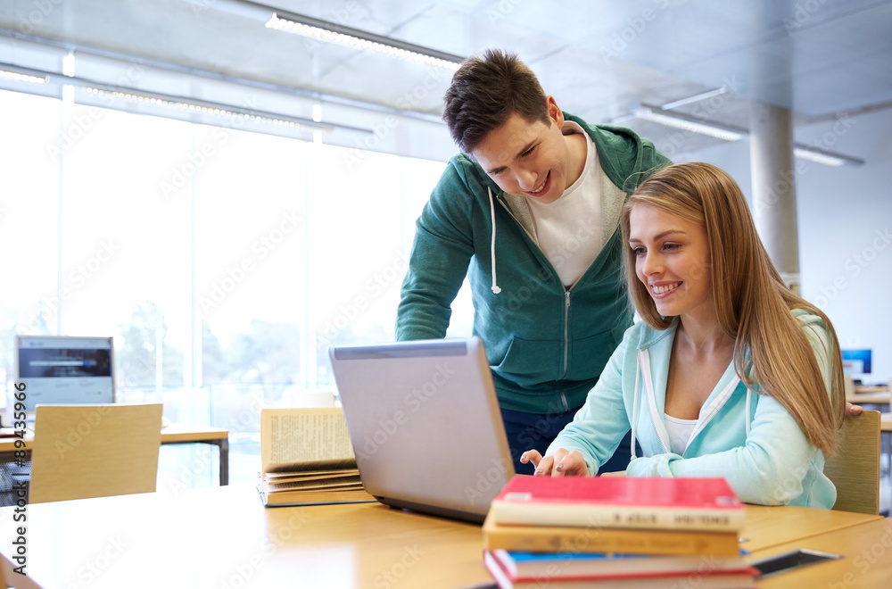happy students with laptop in library happy students with laptop in library