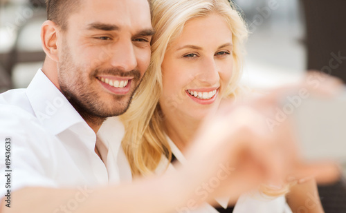 happy couple taking selfie with smatphone outdoors