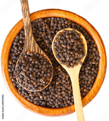 black pepper on wooden spoon with wooden plate isolated on white background.