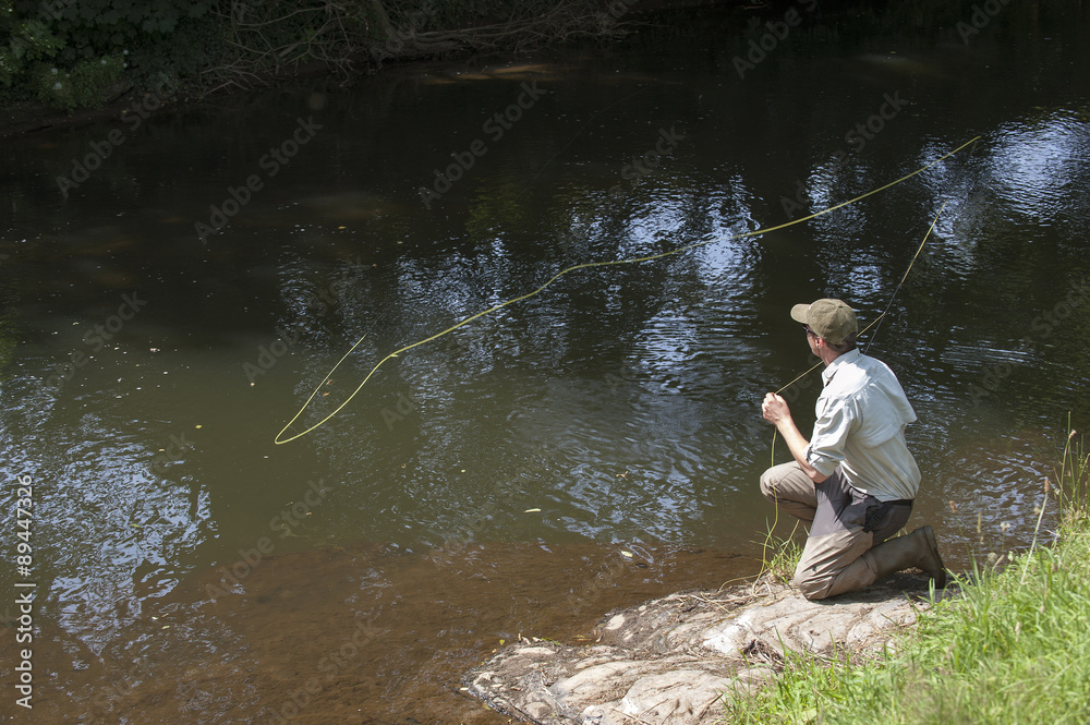 Man fly fishing on River Lyd Devon UK Man fly fishing on River Lyd Devon UK