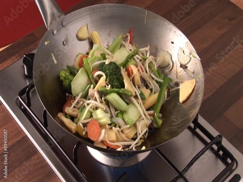 Tossing vegetables and sprouts in a wok photo