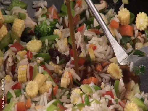 Cooking vegetable rice in a wok, adding soy sauce photo