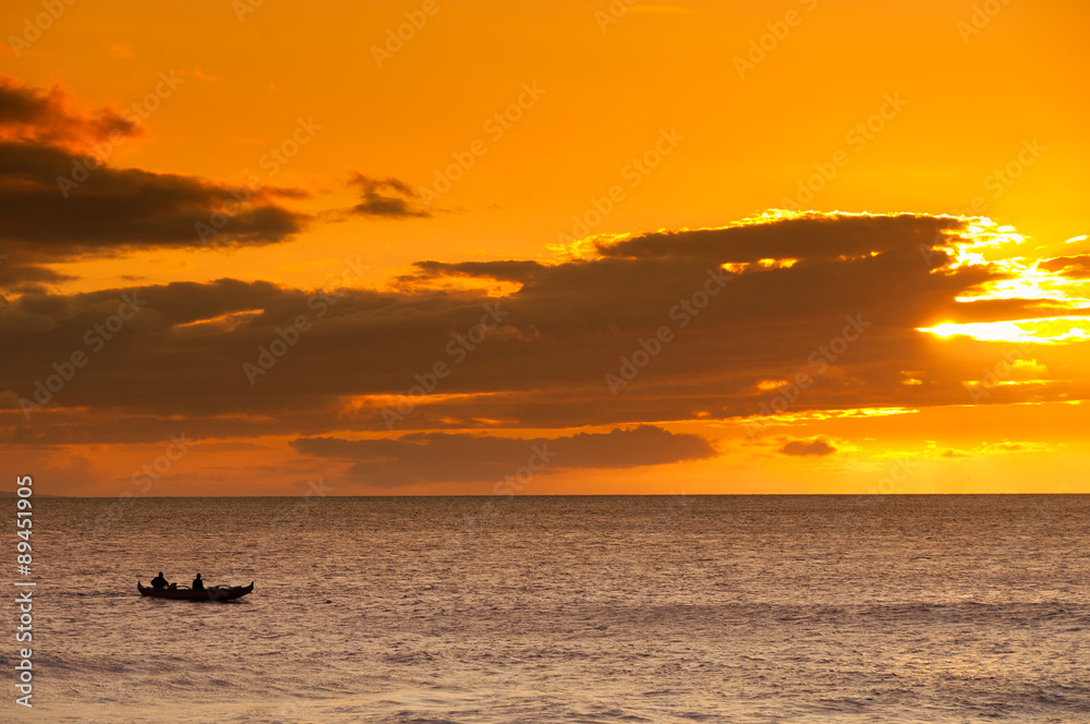 Two men paddling a Hawaiian outrigger canoe at sunset, Maui, Haw