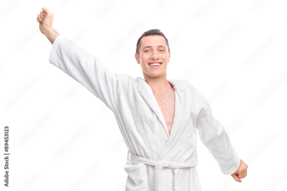 Cheerful young guy in a white bathrobe stretching himself Cheerful young guy in a white bathrobe stretching himself