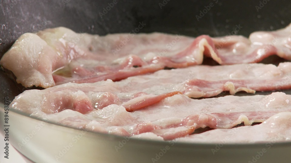 Rashers of bacon being fried in a pan Rashers of bacon being fried in a pan