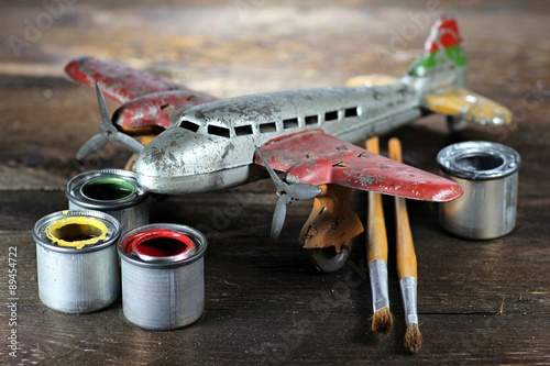 altes Blechflugzeug mit Farbtöpfen und Pinseln zur Restauration photo