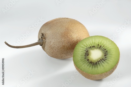 Kiwi fruit half in front of whole kiwi fruit