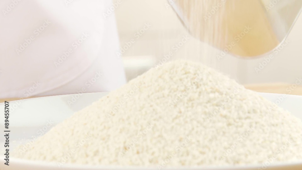 Bread crumbs being poured onto a plate
