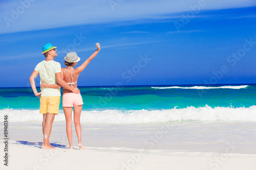 Back view of couple in bright clothes having fun at tropical