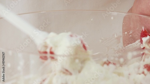 Strawberries being mixed with cream