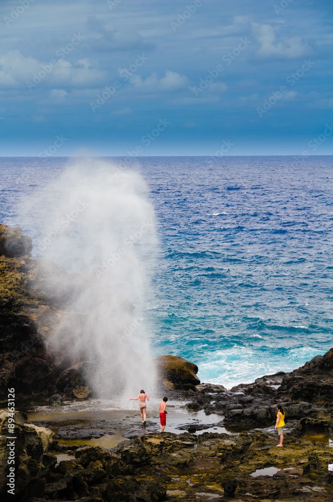Tourists looking at a blow hole on Maui, Hawaii, USA