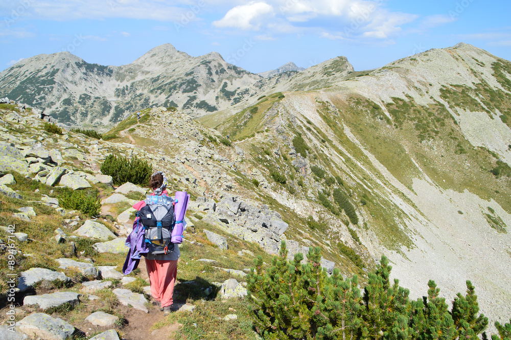 Young Woman Walking On A Trail High Mountain Ridge
