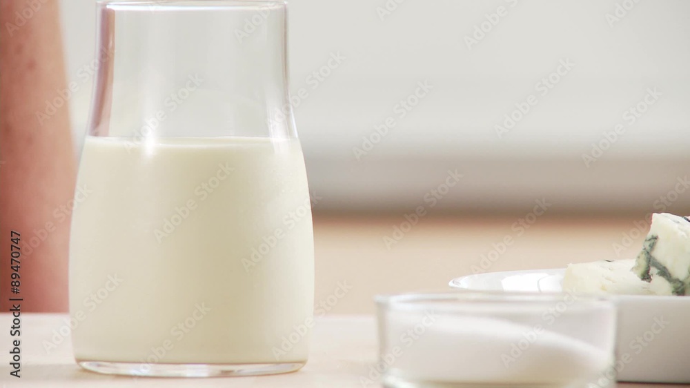 A hand taking stock, cream and salt A hand taking stock, cream and salt