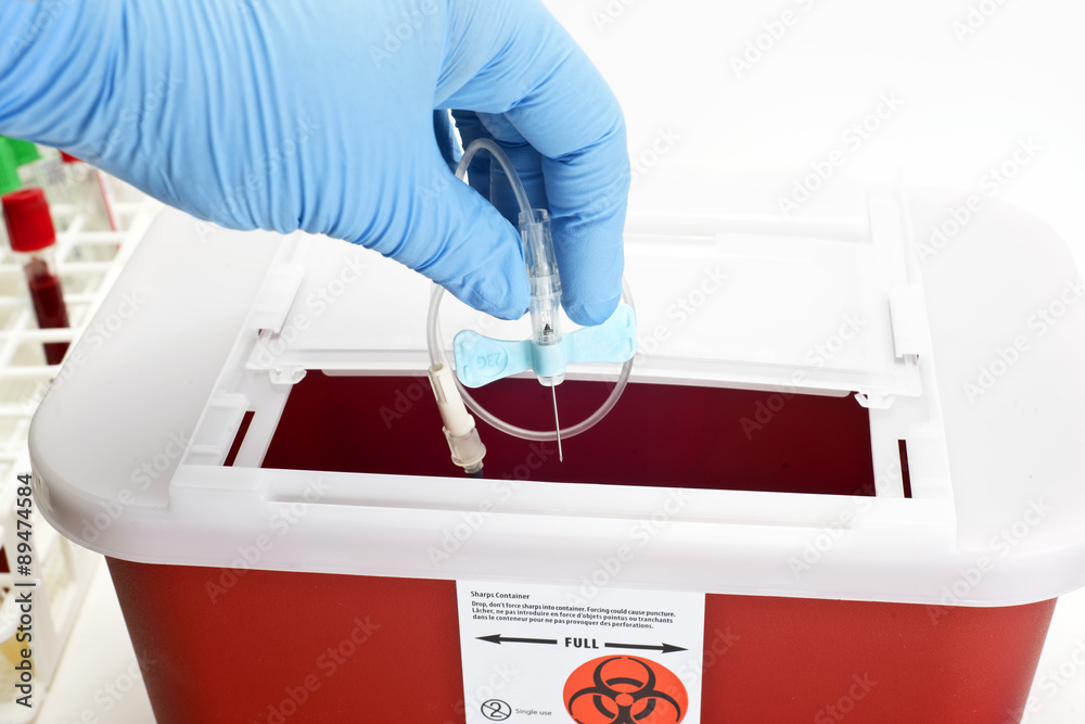 Technician drops catheter into sharps container Stock Photo Adobe Stock