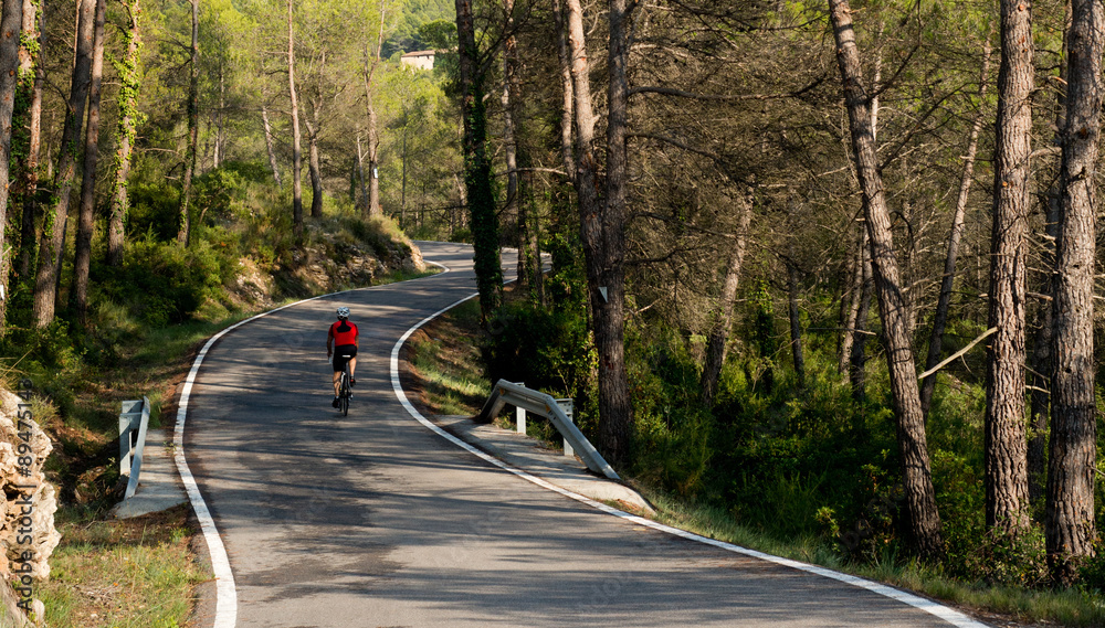 Fototapeta premium Cyclist in road with curves