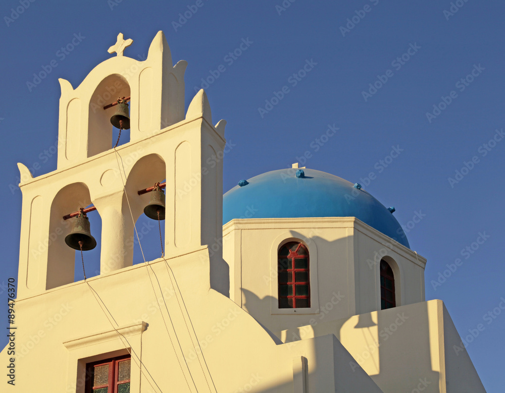 Blue dome greek orthodox church and belltower in Oia on Santorini