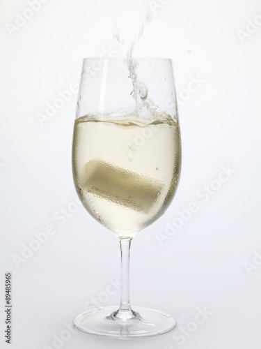 Cork falling into a glass of white wine