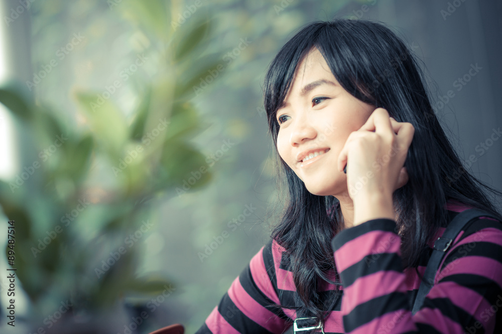 Beautiful asian young woman speaking by mobile phone Beautiful asian young woman speaking by mobile phone