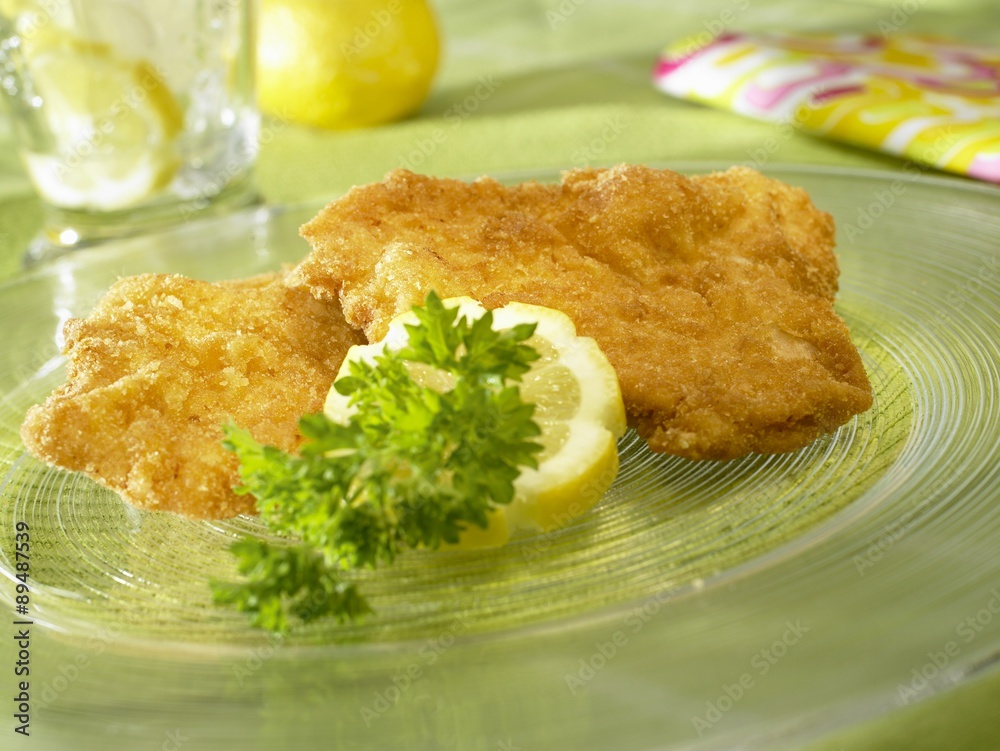 Wiener schnitzel (breaded veal escalopes) with lemon & parsley on glass
