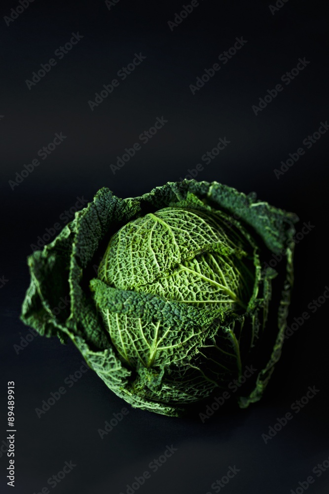 A savoy cabbage against a black background A savoy cabbage against a black background
