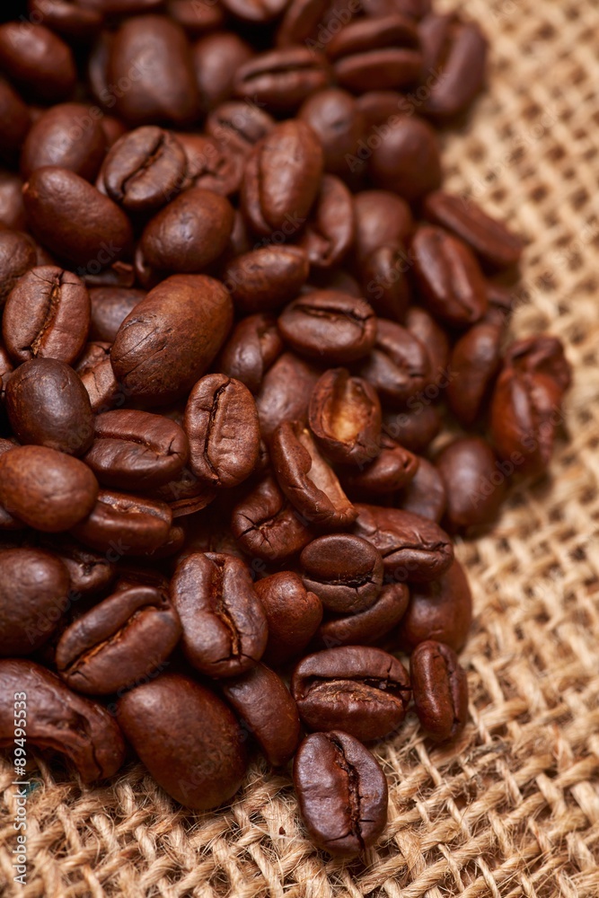 Lots of whole, roasted coffee beans on jute Lots of whole, roasted coffee beans on jute