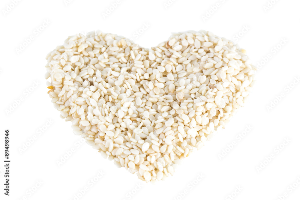 Heart shape made of sesame seeds with no shell, tilted angle, isolated on white background. Heart shape made of sesame seeds with no shell, tilted angle, isolated on white background.