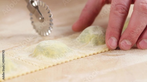 Ravioli being cut out with a dough wheel