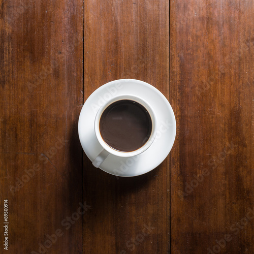 Coffee cup on wooden background, top view