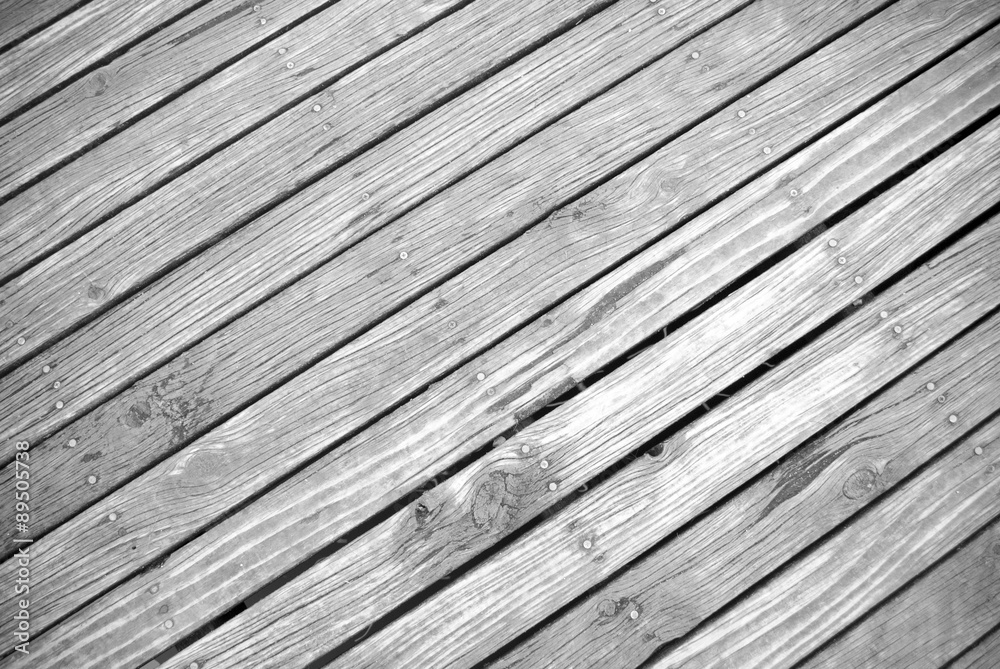 angled ground view of textured timber boardwalk in black and white angled ground view of textured timber boardwalk in black and white