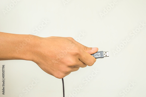 Man hand holding usb cable