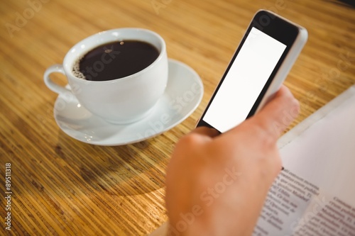 Man using smartphone and having coffee