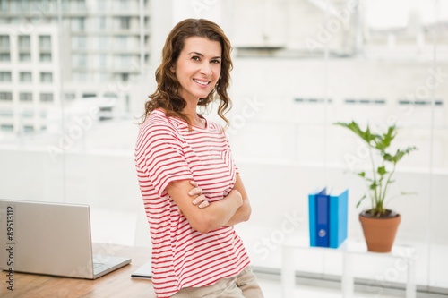 Smiling casual businesswoman with arms crossed
