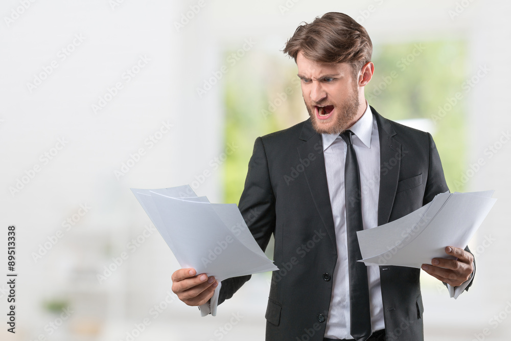 Businessman confused with a lot of paperwork
