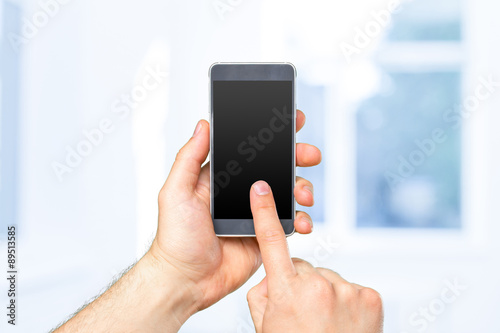 Fototapeta Naklejka Na Ścianę i Meble -  Man's hand holding smartphone