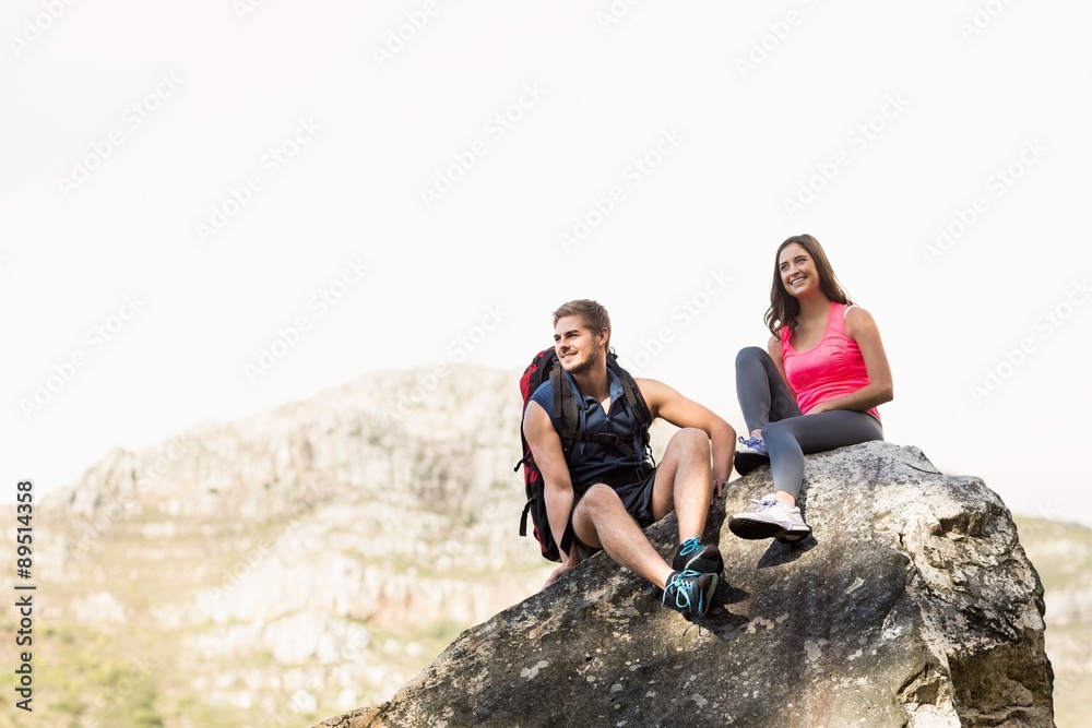 Young happy joggers sitting on rock