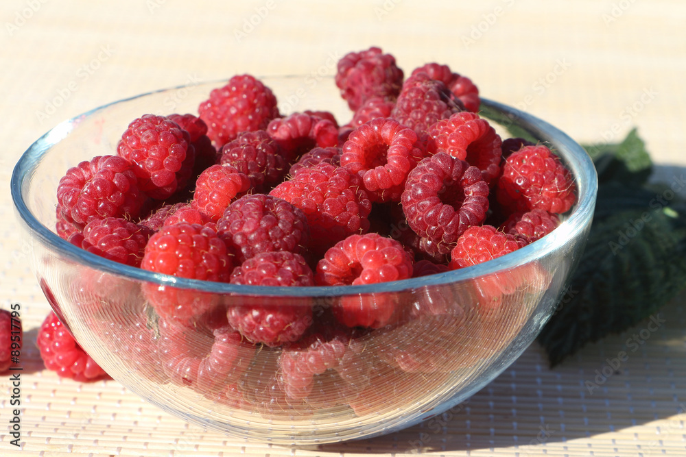 Basket with fresh ripe raspberries standing on a table in a garden
Basket with fresh ripe raspberries standing on a table in a garden