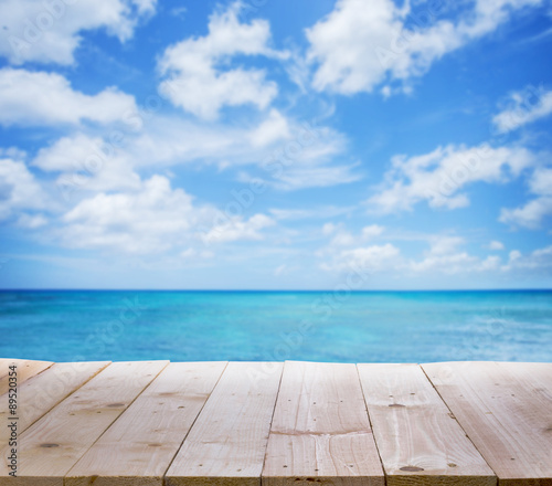 Wood table with blur seascape and blue sky background