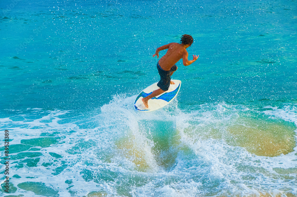 Teenage boy skimboarding on Maui, Hawaii, USA