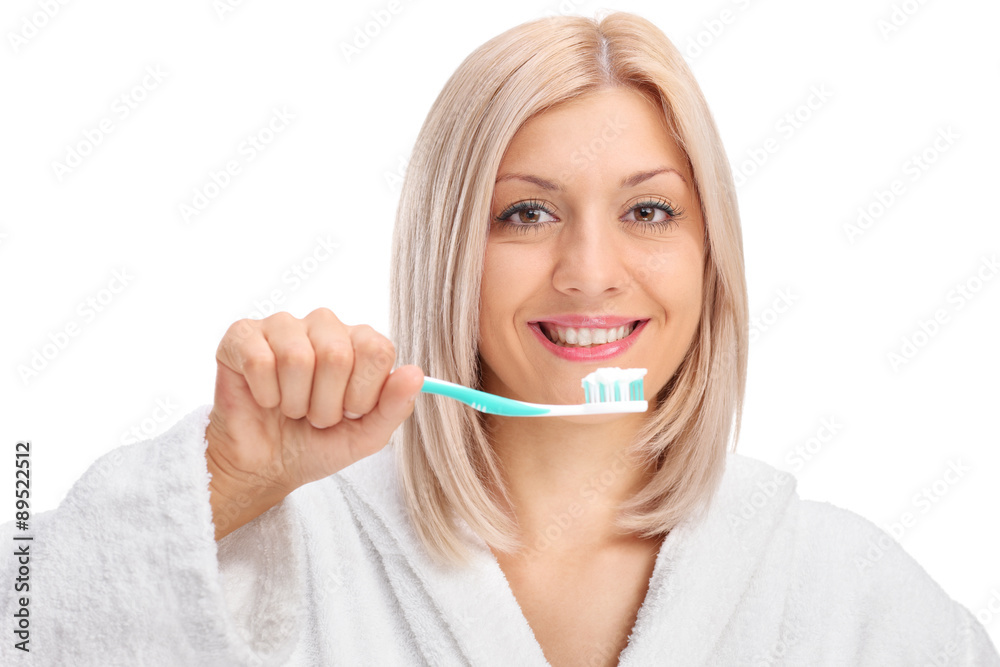 Young woman in a bathrobe holding a toothbrush Young woman in a bathrobe holding a toothbrush