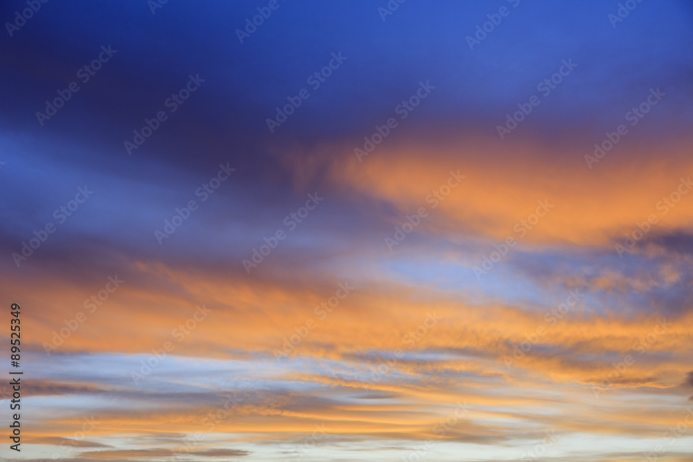 September evening skyscape with clouds lit by red sunset against a dark blue sky. UK Britain