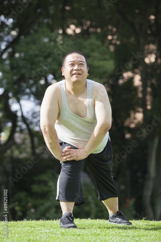 Fototapeta Naklejka Na Ścianę i Meble -  公園で運動する中年男性