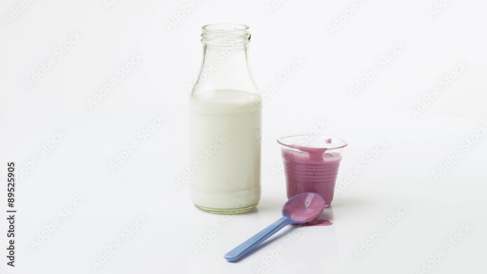 Cherry yoghurt in pot, spoon and a bottle of milk Cherry yoghurt in pot, spoon and a bottle of milk