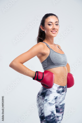 Smiling fitness girl standing in boxing gloves