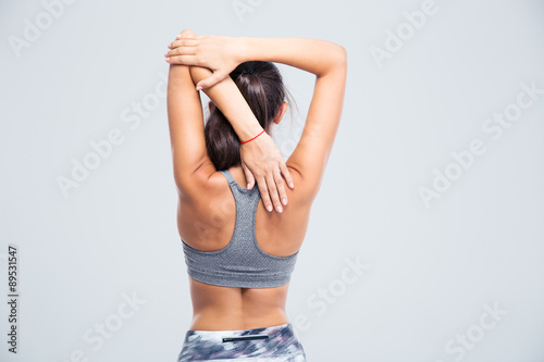 Back view portrait of a young woman stretching hands